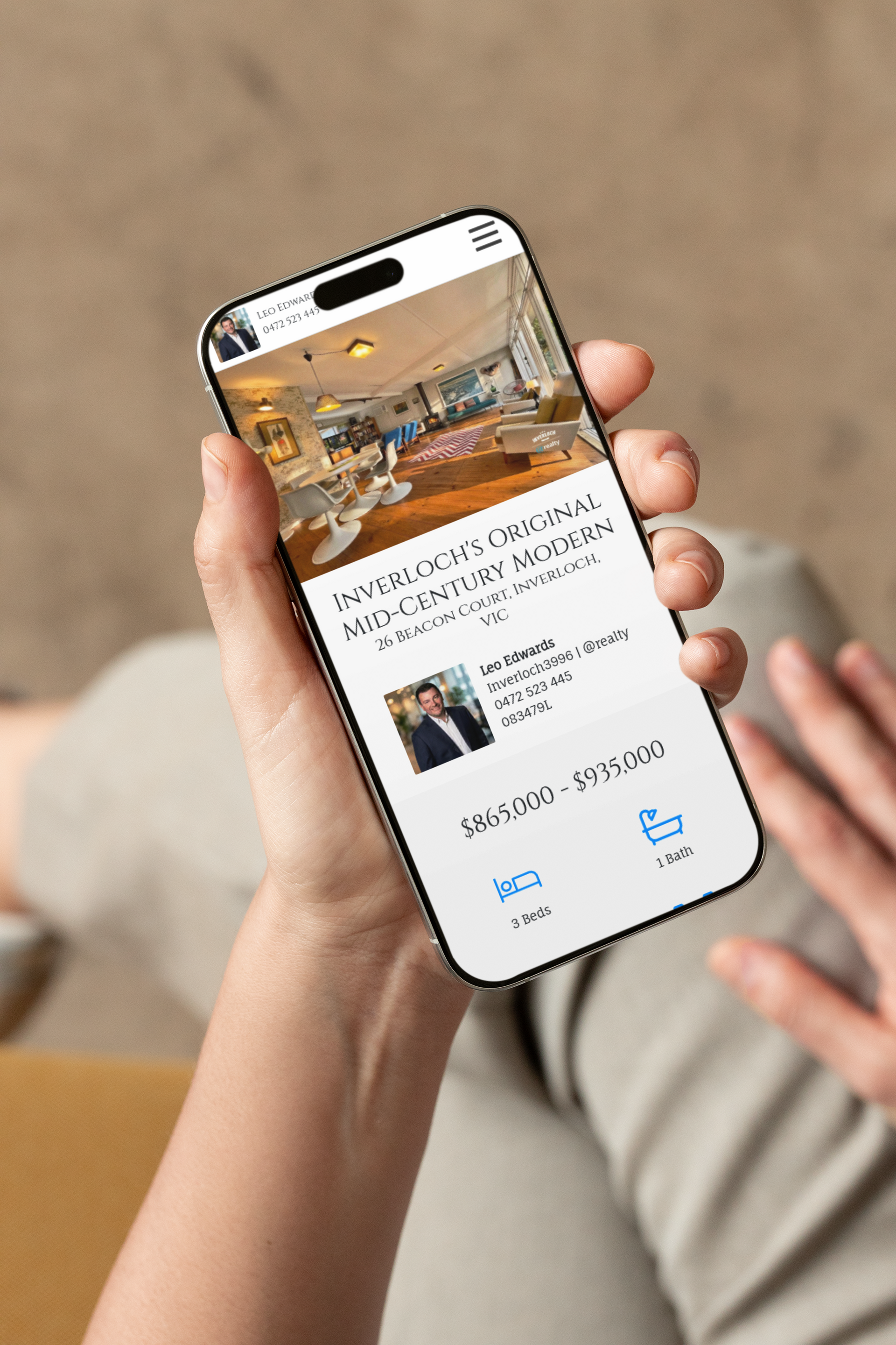 Hand holding a smartphone showing a hotel booking screen with a room photo and details.