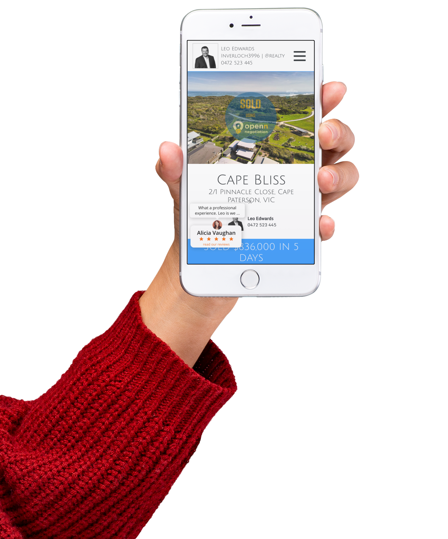A person in a red sweater is holding a cell phone