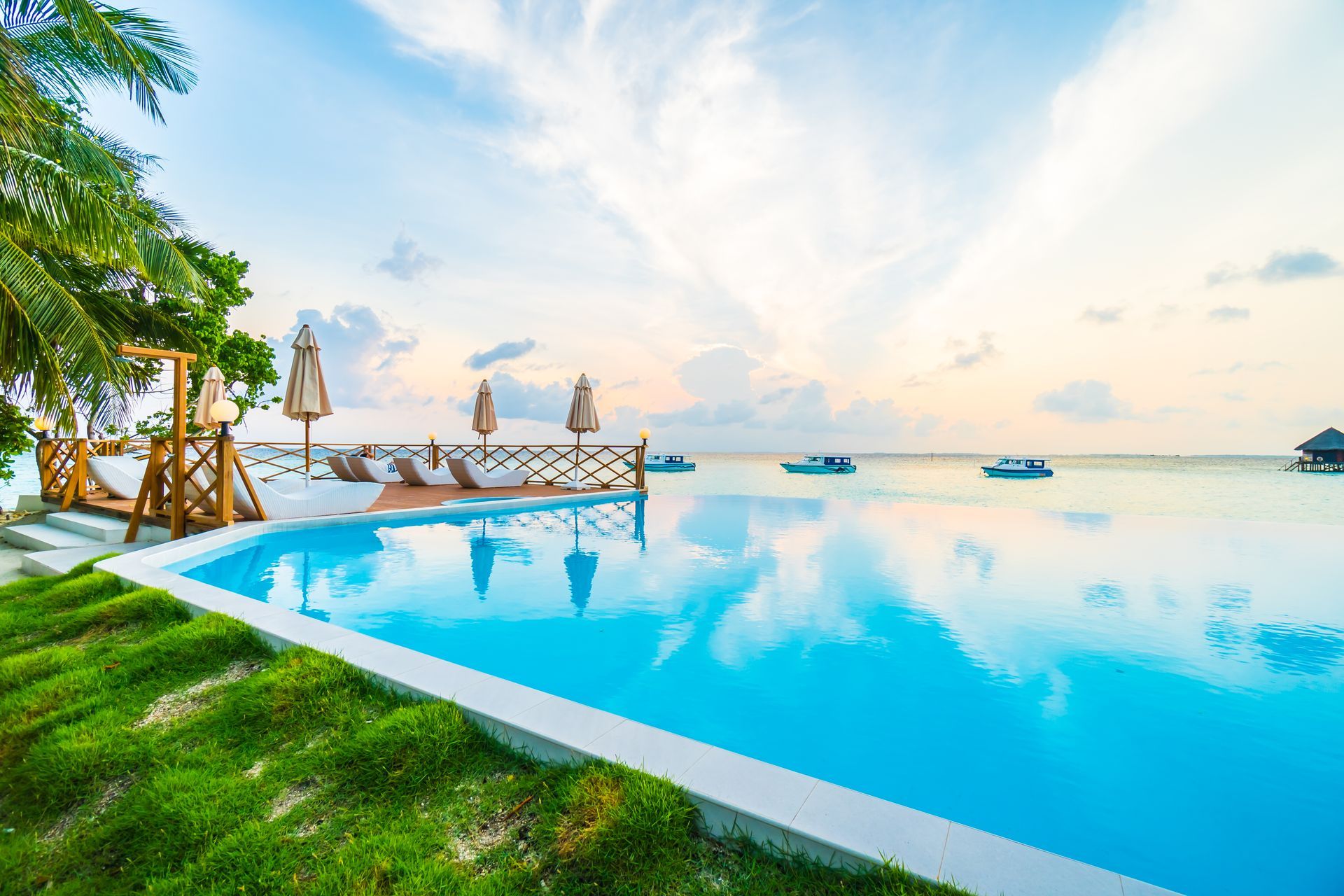 There is a swimming pool with a view of the ocean.