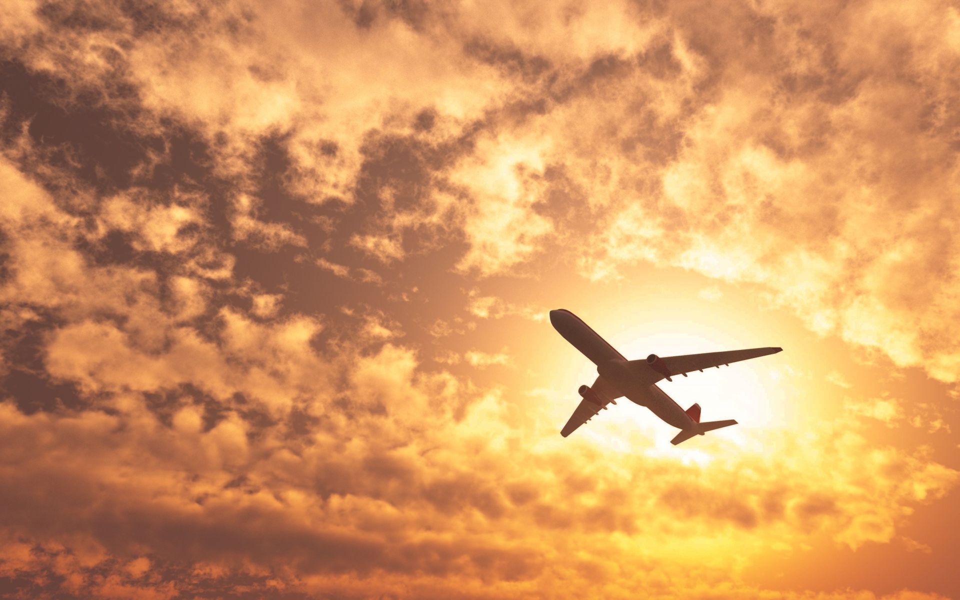 A plane is flying in the sky at sunset.