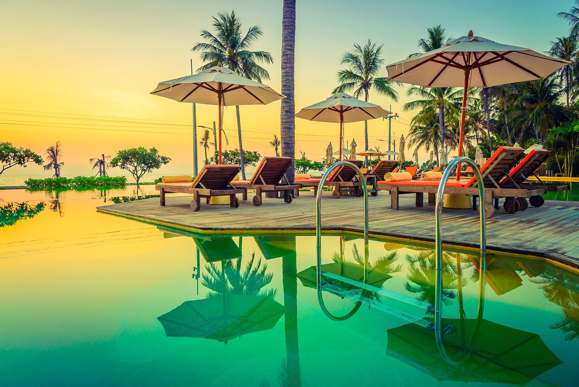A swimming pool surrounded by chairs and umbrellas at a resort.