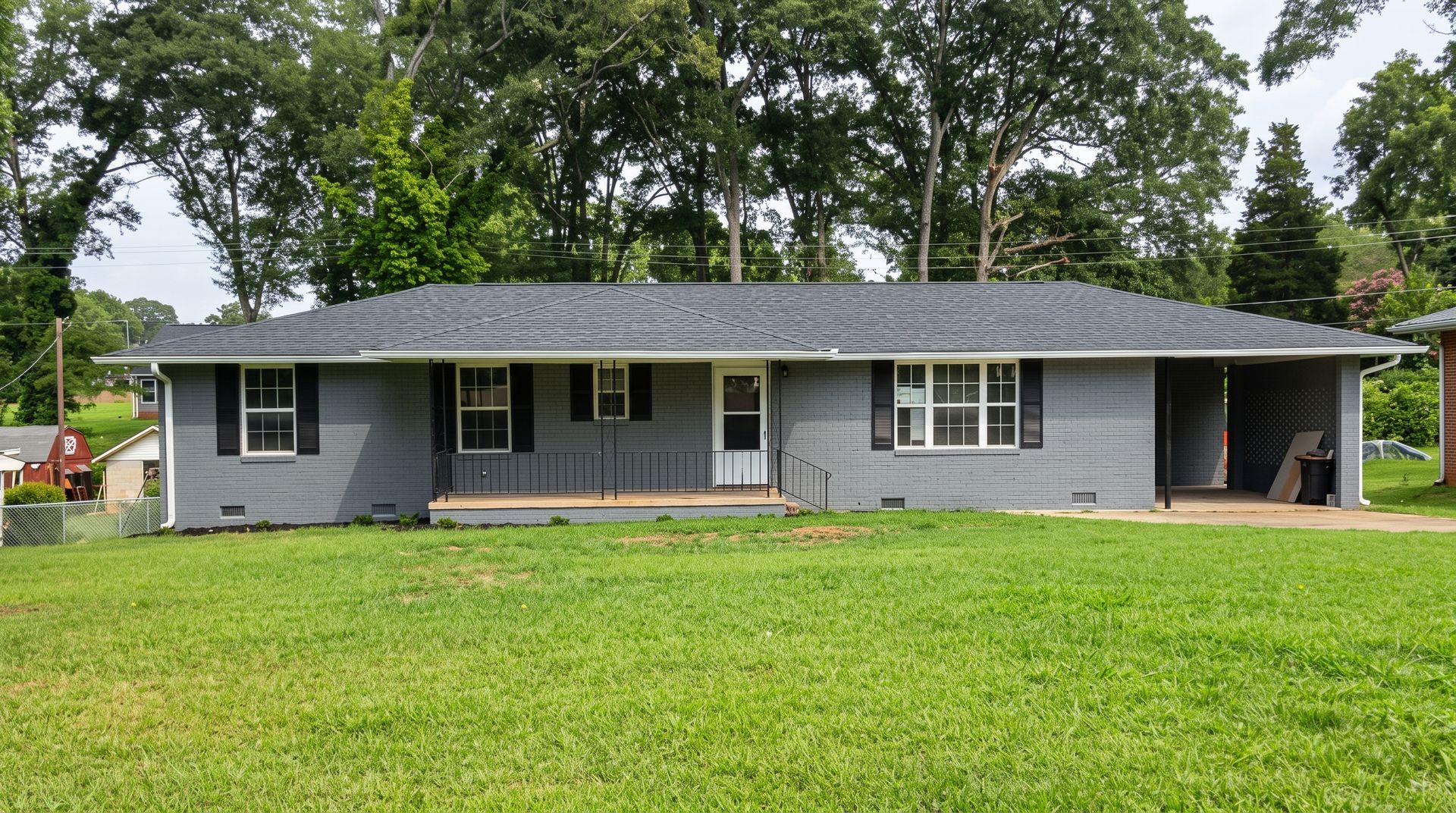Gray two-story suburban house with front porch, white trim, and a driveway in a landscaped yard