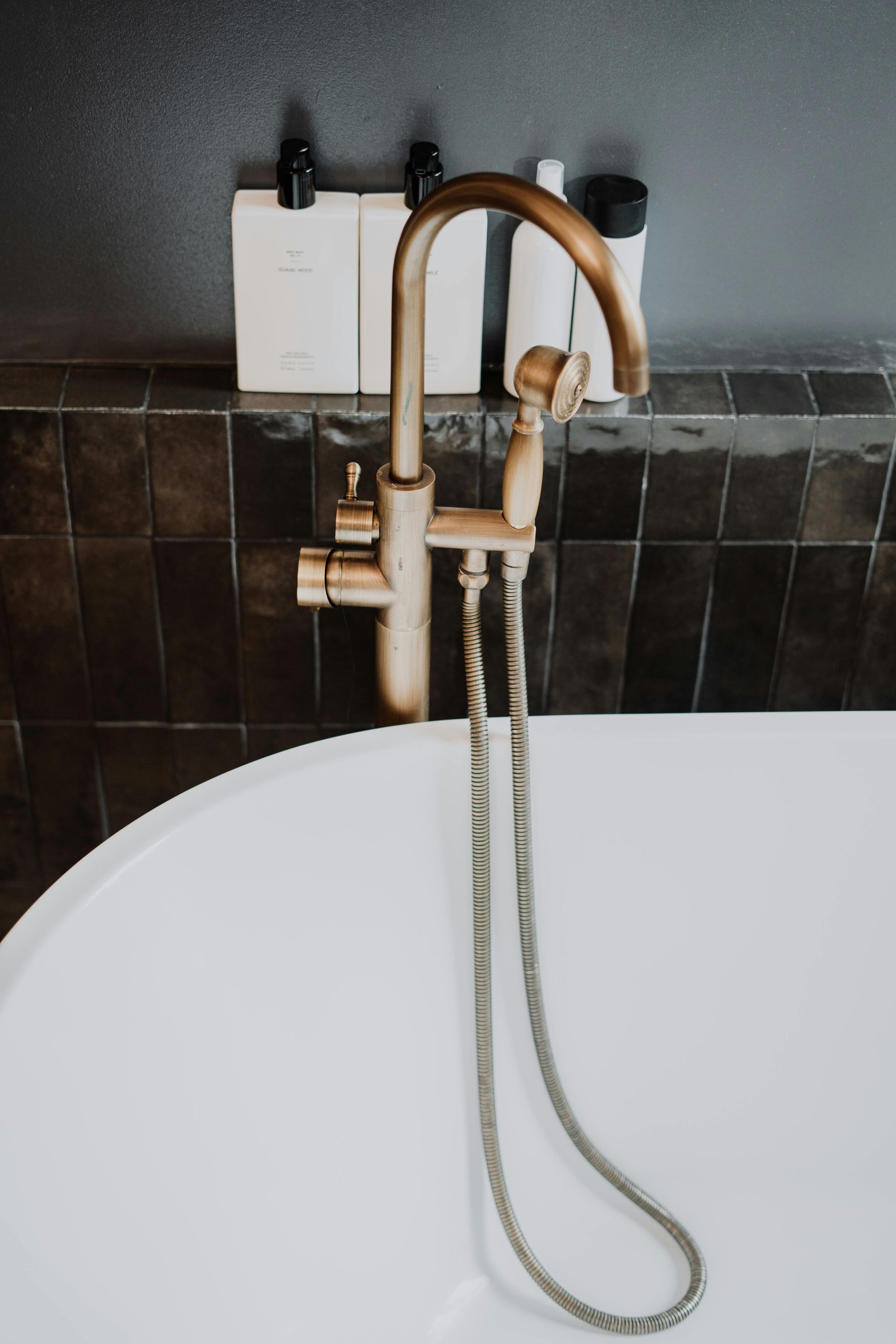 A bathtub with a brass faucet and a shower head attached to it.