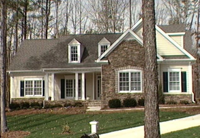 Story and a half craftsman custom build with stone accents on a wooded lot in Holly Springs NC