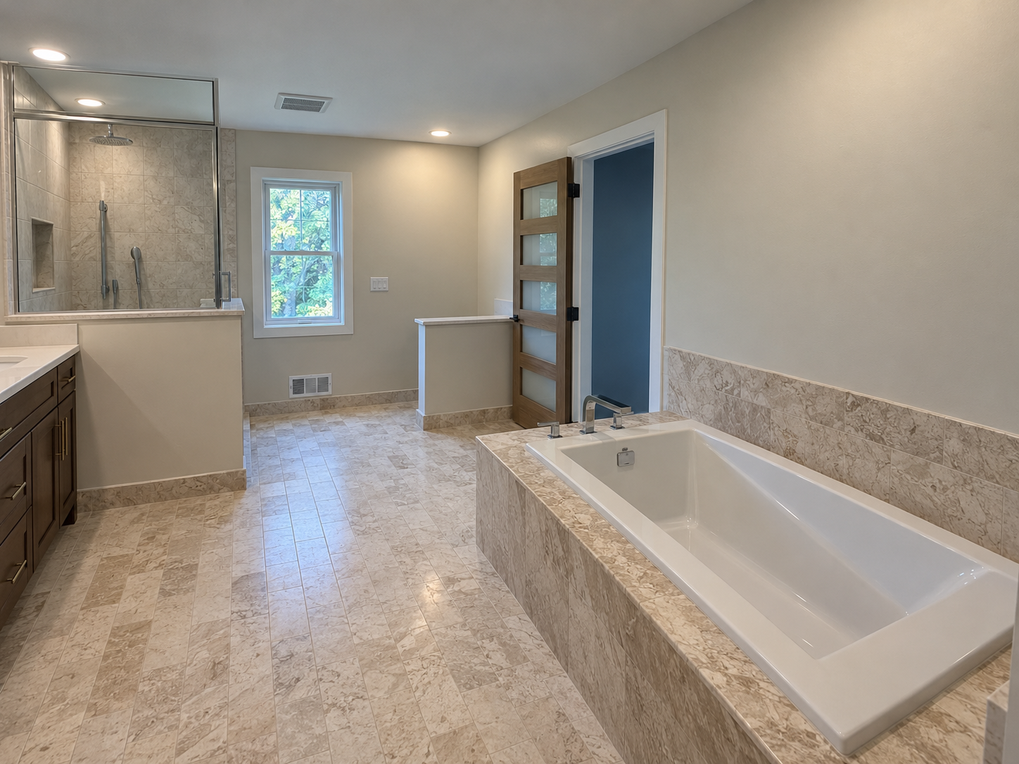 Bright bathroom with a large tub, glass shower, white tile, and windowed door.
