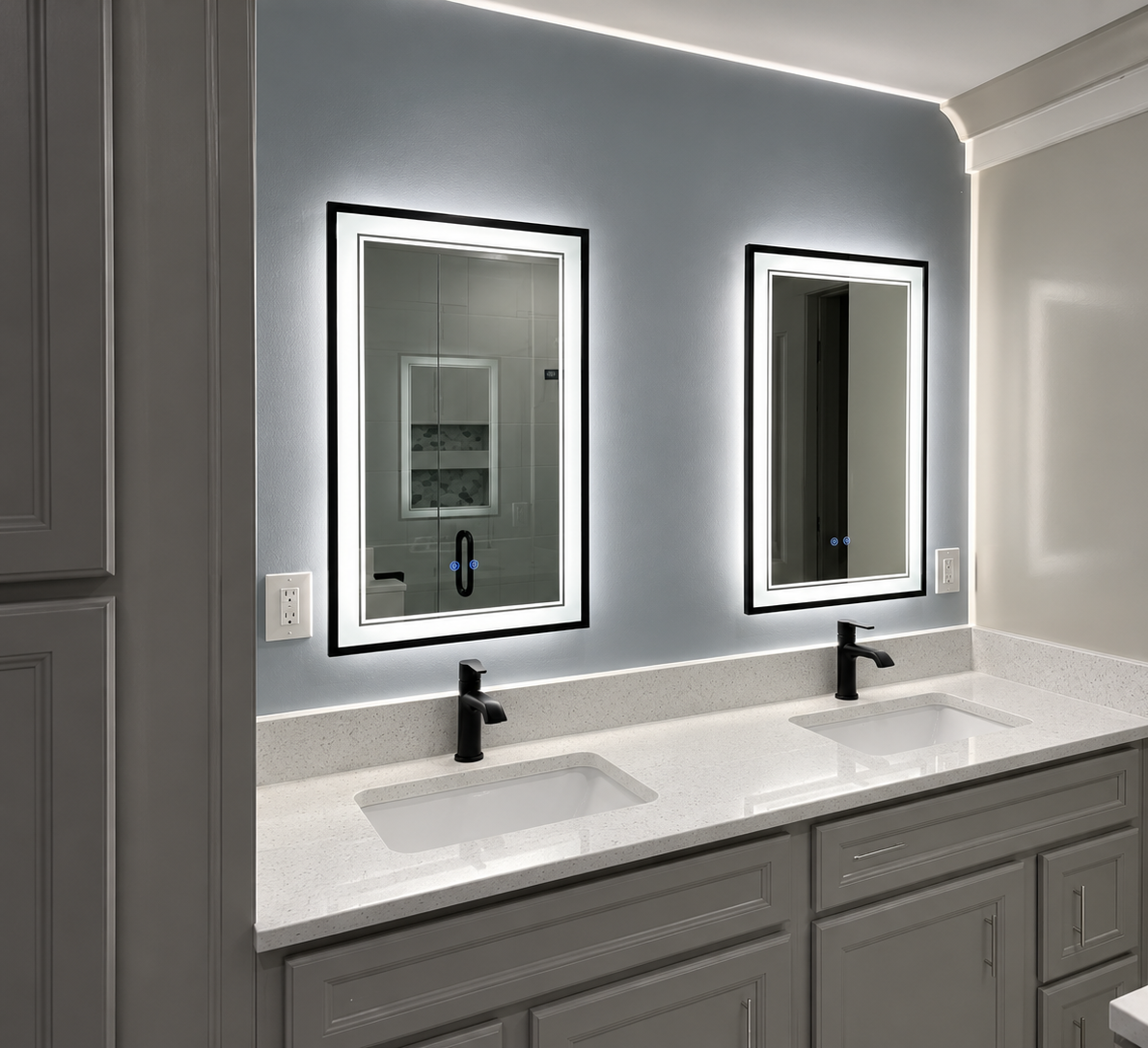 Modern bathroom vanity with two lit mirrors, black faucets, and gray cabinets