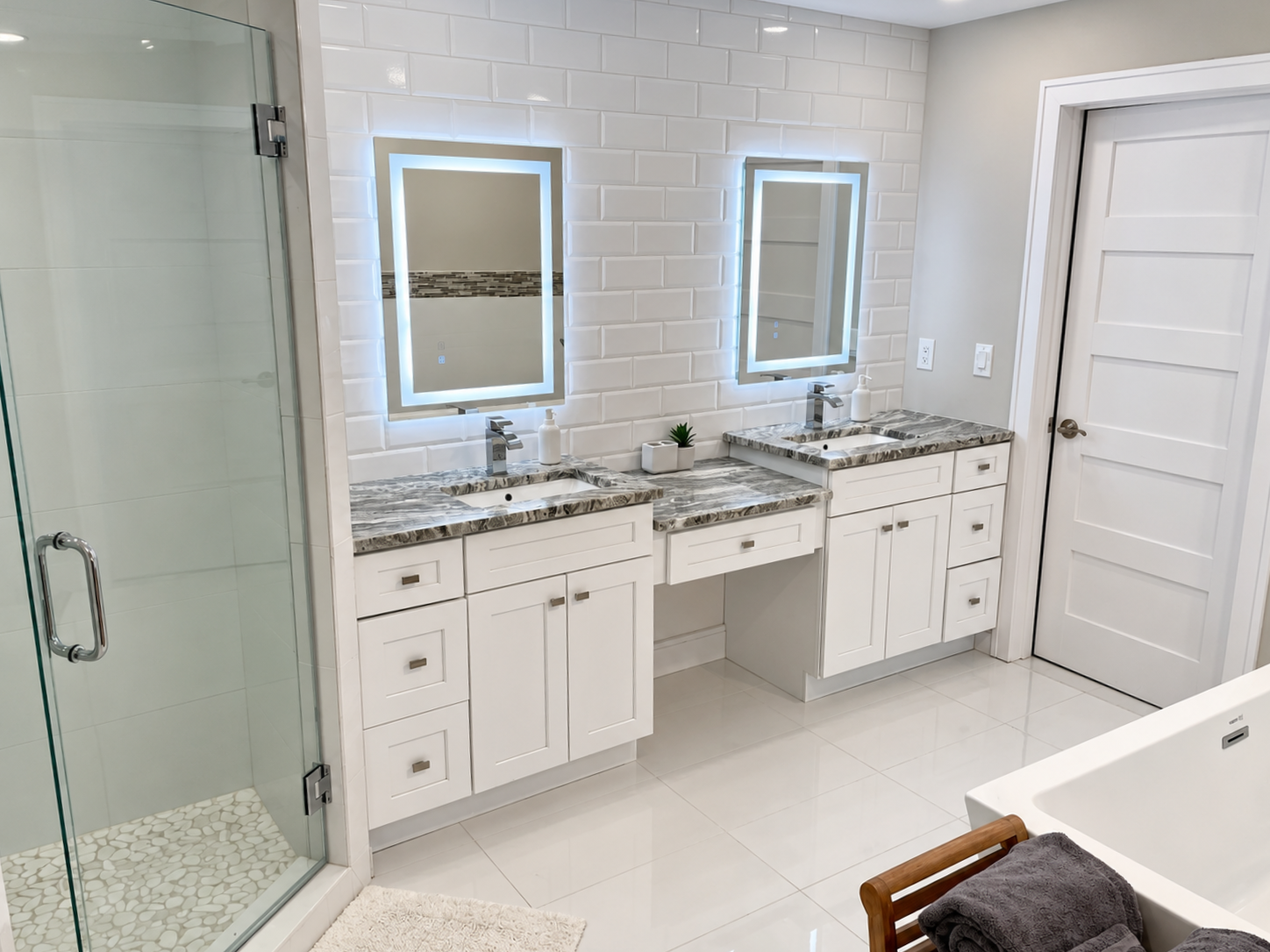 Small bathroom with toilet, vanity, shower, and tools on the floor, suggesting ongoing repairs.