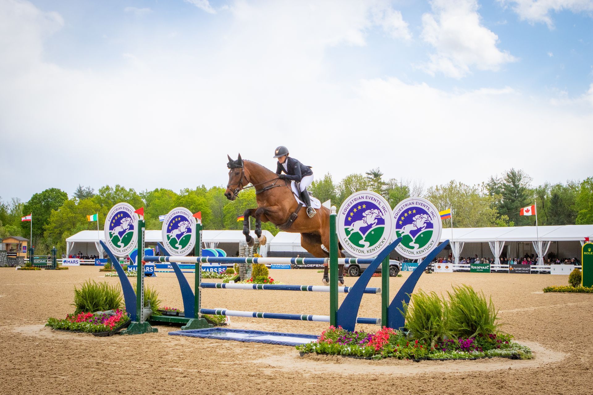 A person is riding a horse over a jump.
