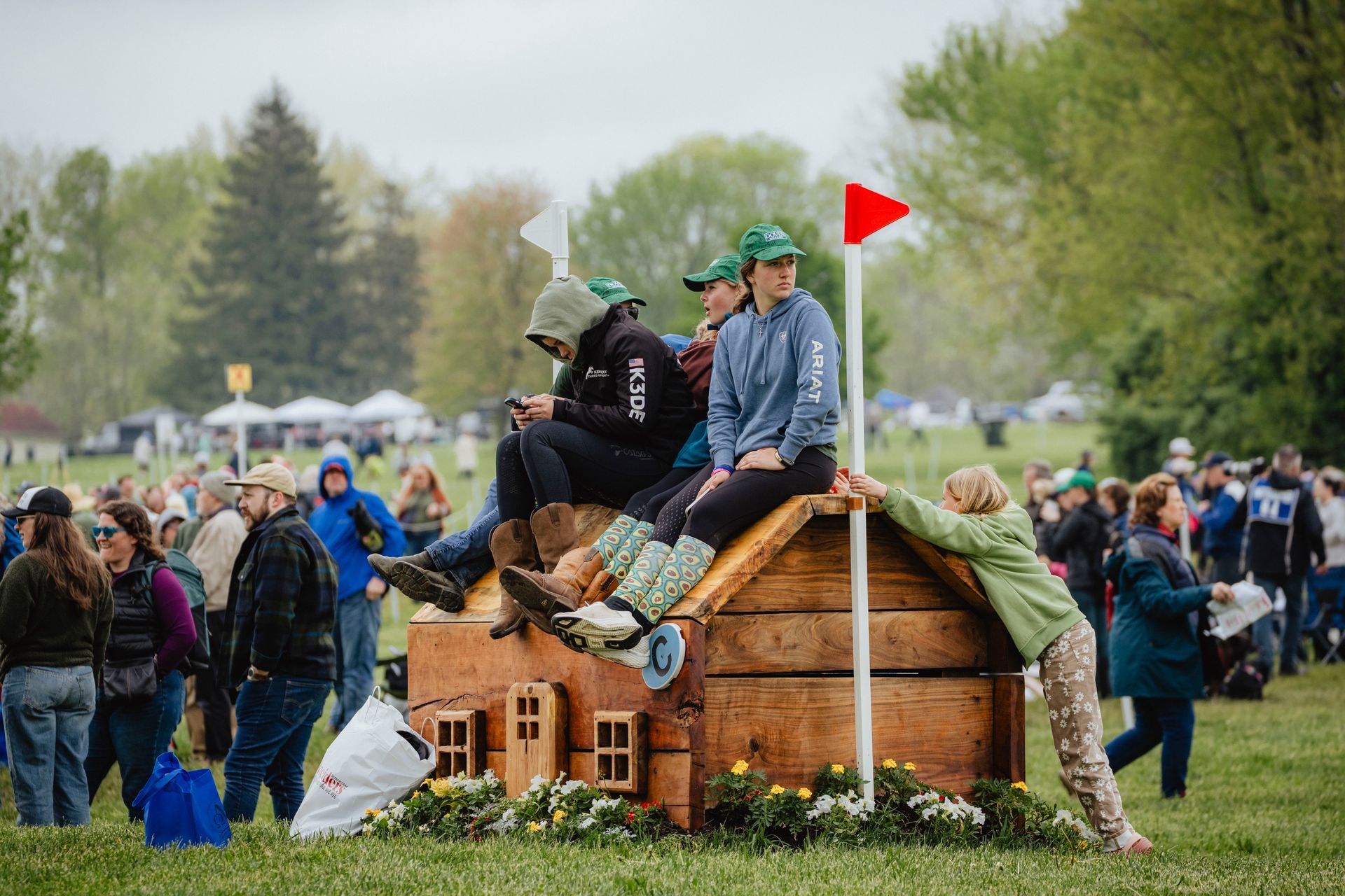 A group of teenagers sitting on a wooden jump