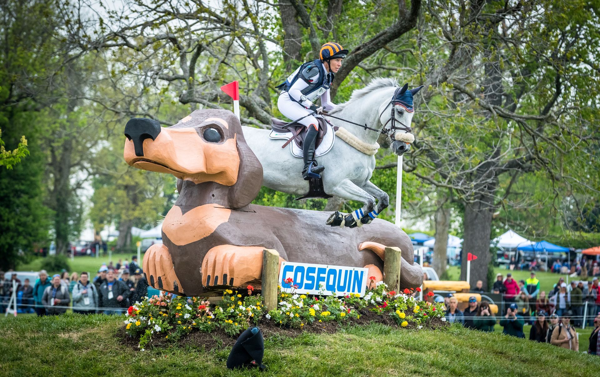 A woman is riding a horse on top of a giant inflatable dog.