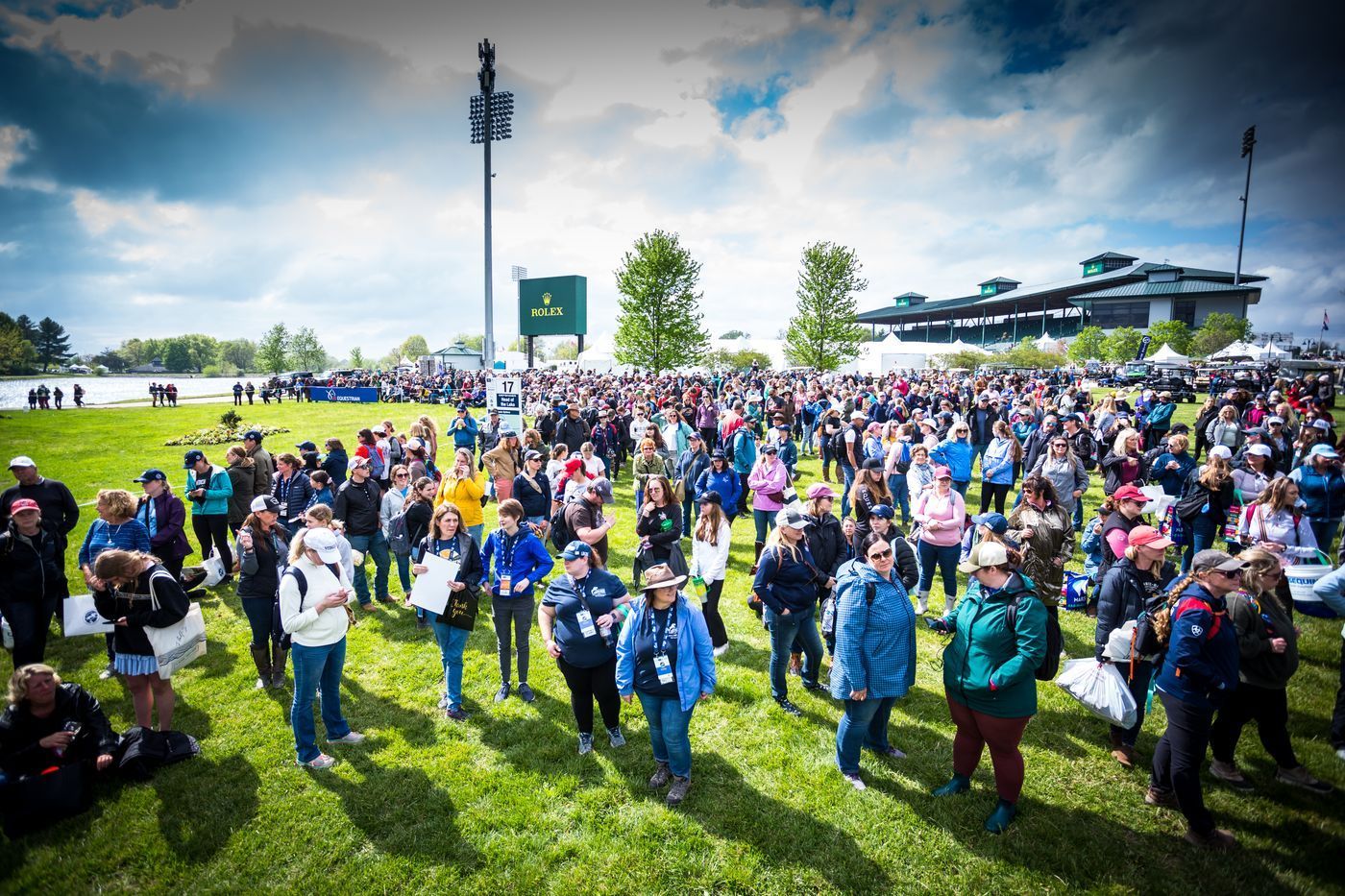A large group of people are standing in a grassy field.