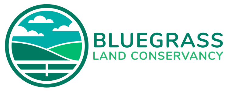 The logo for bluegrass land conservancy is a circle with a landscape in it.