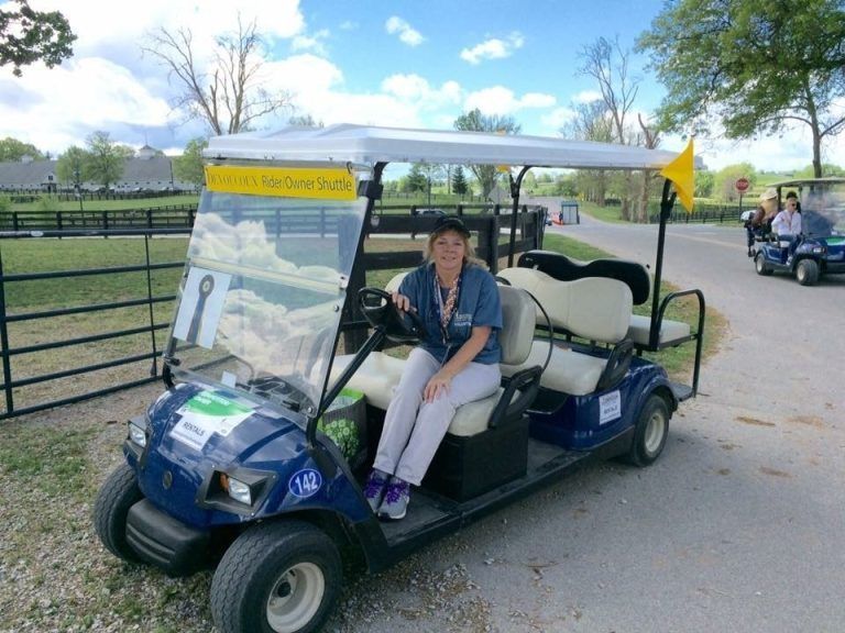 A woman sits in a golf cart