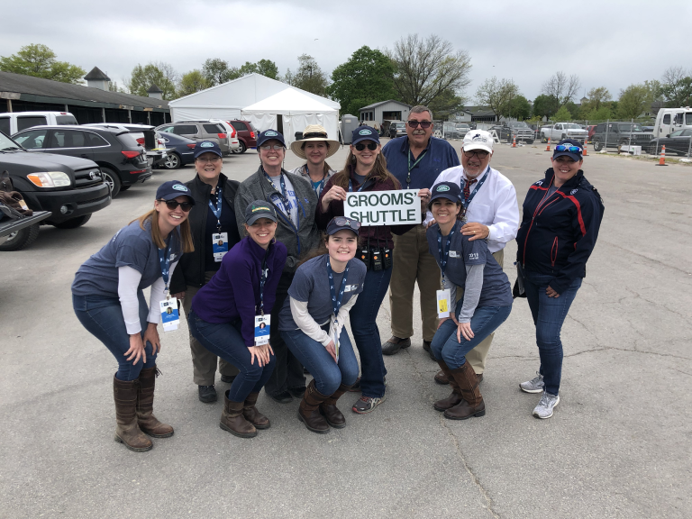 A group of people holding a sign that says grooms shuttle