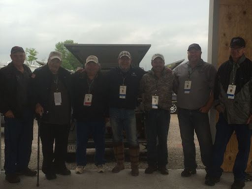 A group of men are posing for a picture in front of a truck.