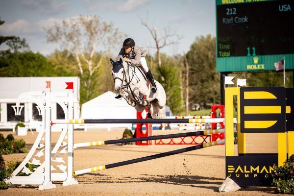 A person is jumping a hurdle on a horse.