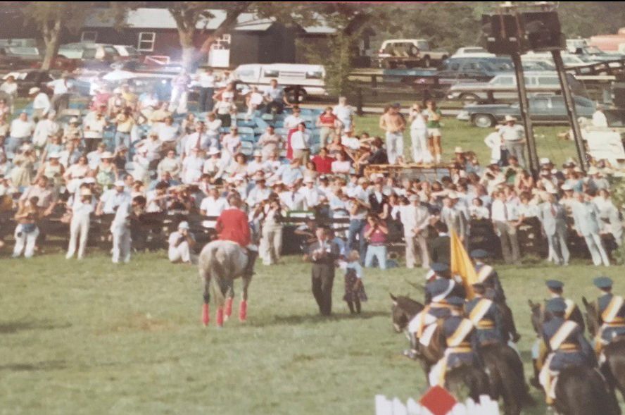 A man riding a horse in front of a crowd of people