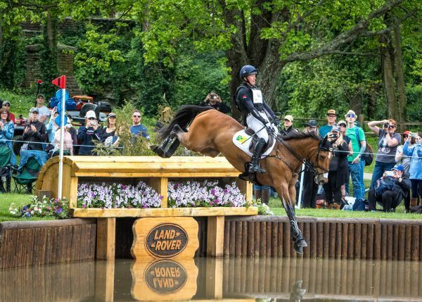 A person is riding a horse over a pond.