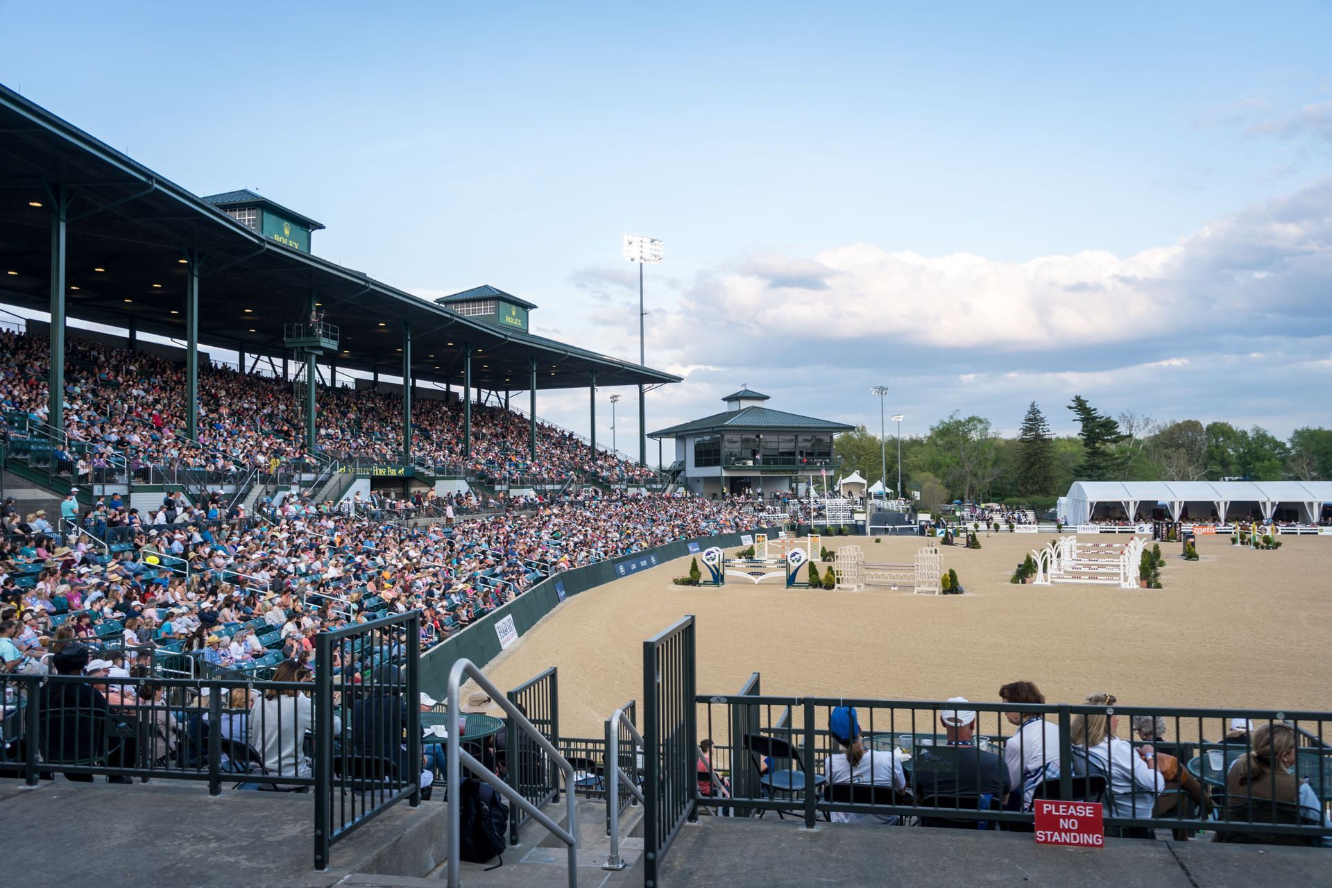 A stadium filled with people watching a horse race