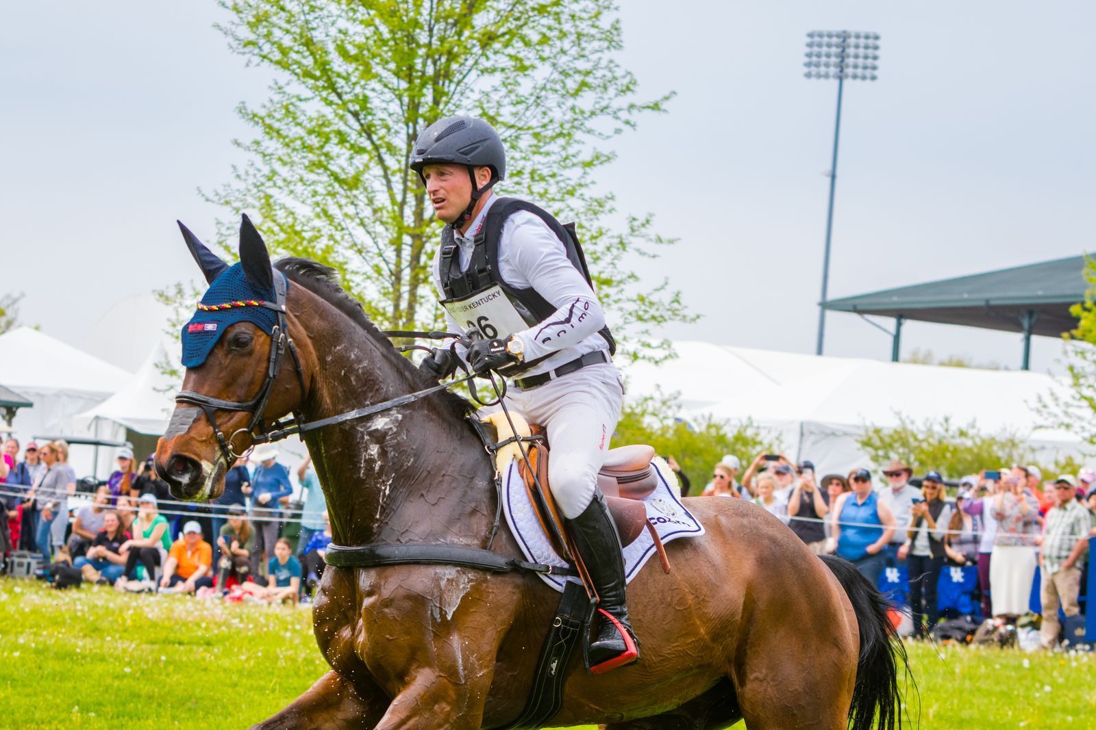 A man is riding a brown horse in a field.