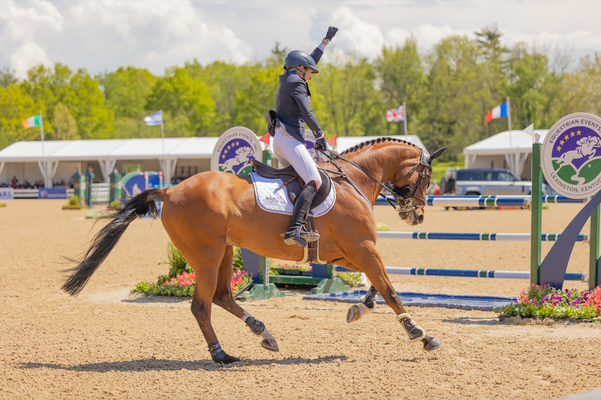 A woman is riding a brown horse in a jumping competition.