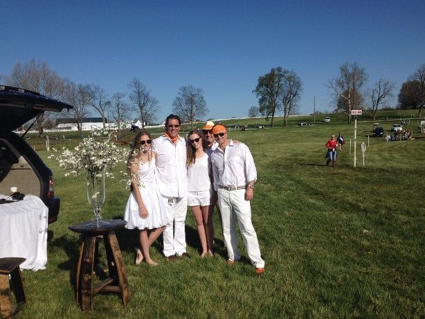 A group of people posing for a picture in a grassy field
