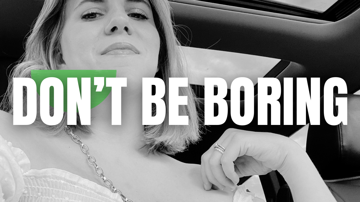 A woman is sitting in a car with the words do n't be boring above her.