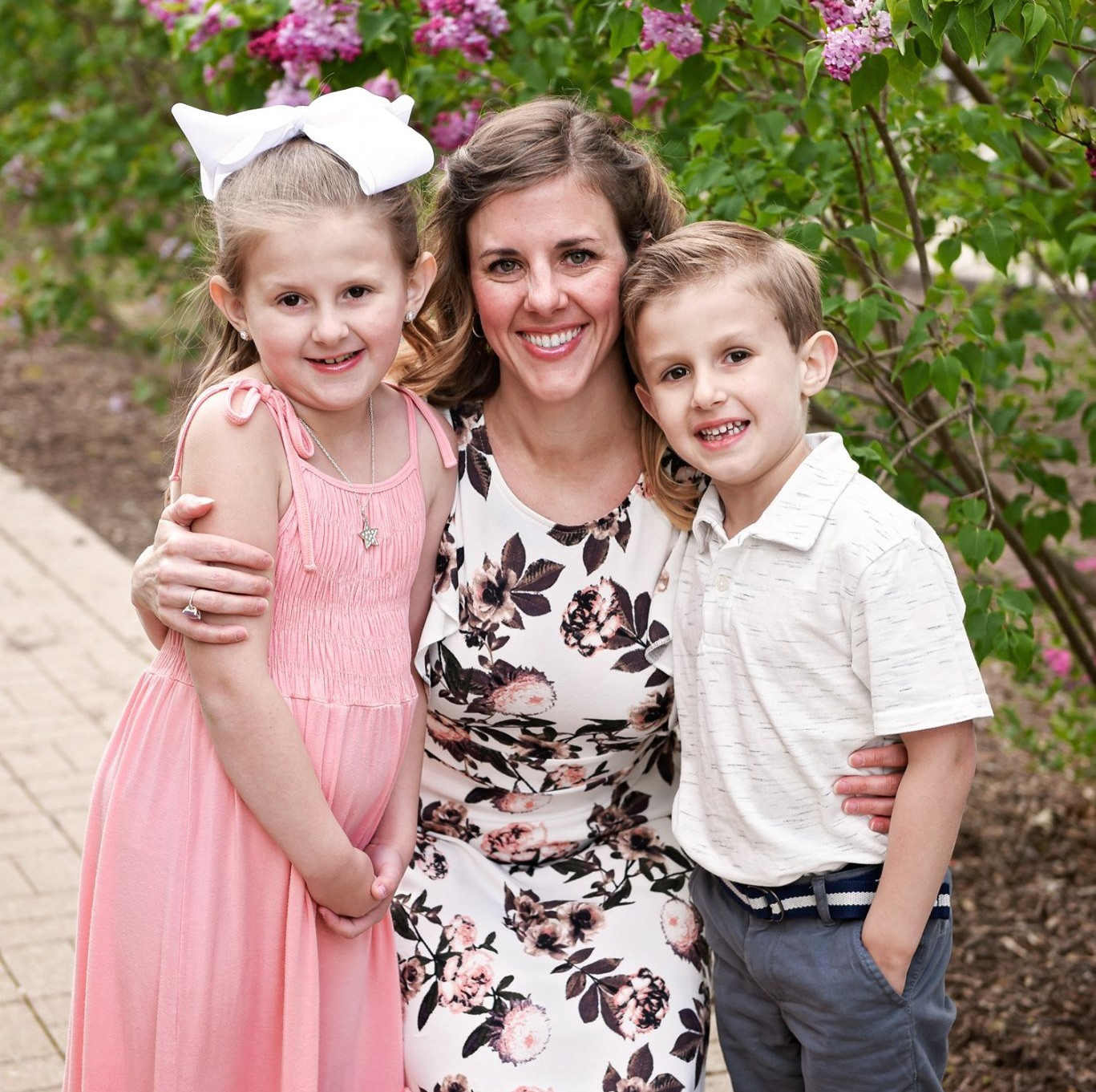 A woman is posing for a picture with two children.