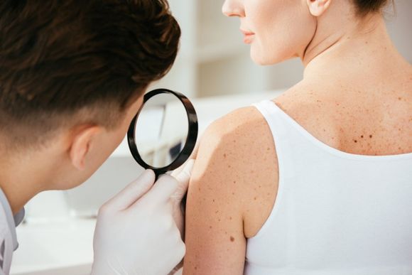 dermatologo esamina pelle paziente donna