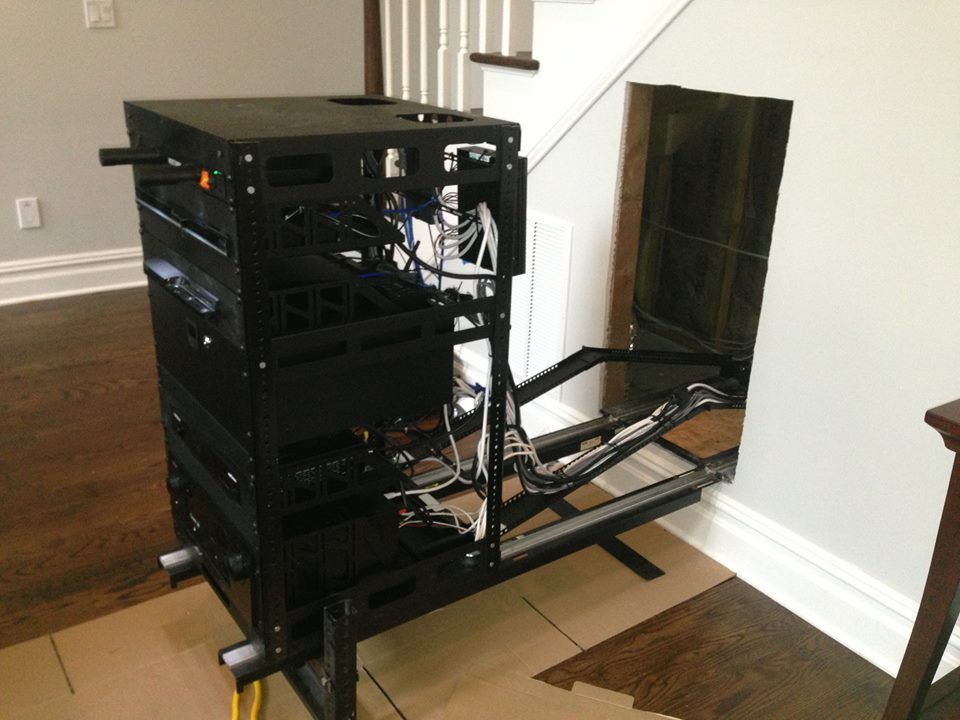 Open computer case and sliding rack in a room with wood floor by Audio Video Concepts