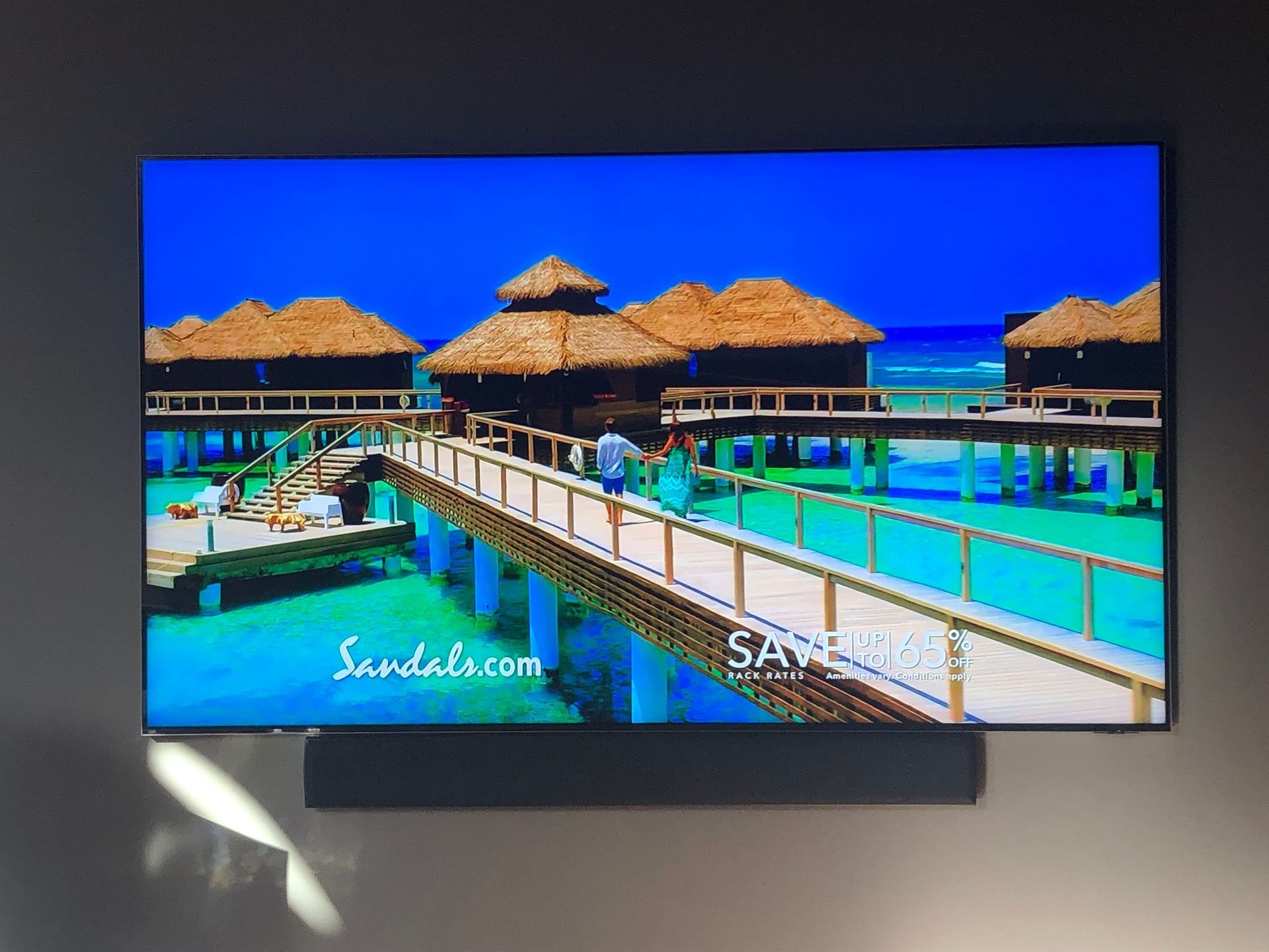 Tropical resort overwater bungalows and boardwalk over turquoise water under a bright blue sky by Audio Video Concepts