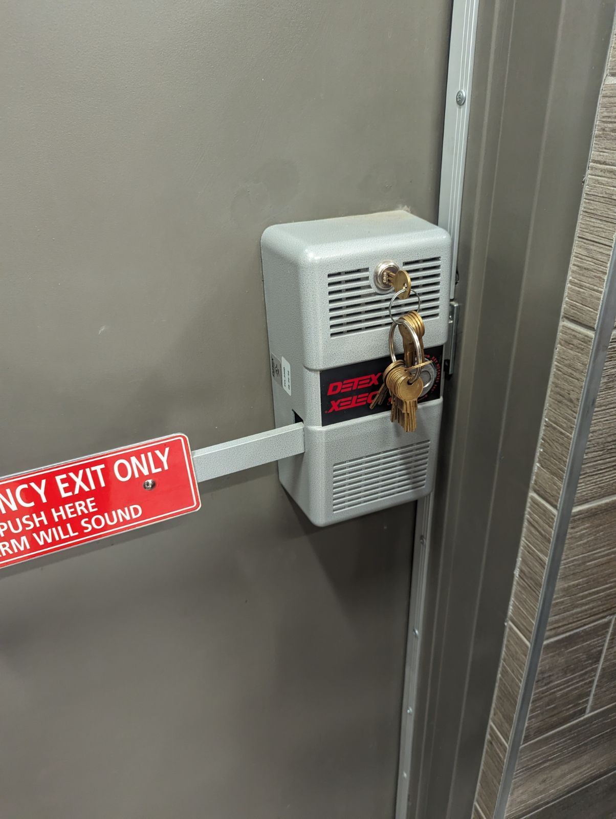 A emergency exit only sign is attached to a door.