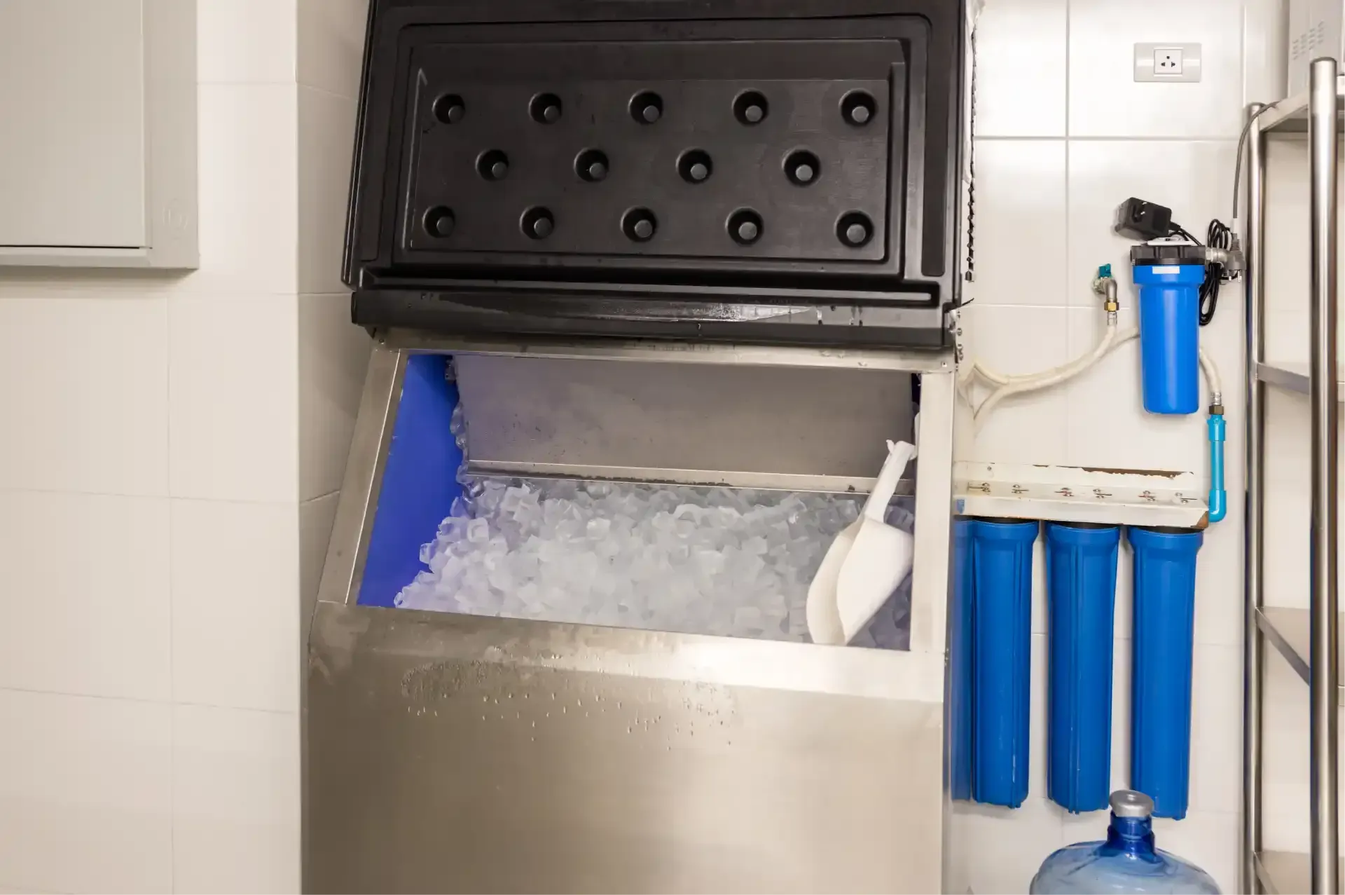 Hand tightening a pipe fitting under a sink with adjustable wrenches