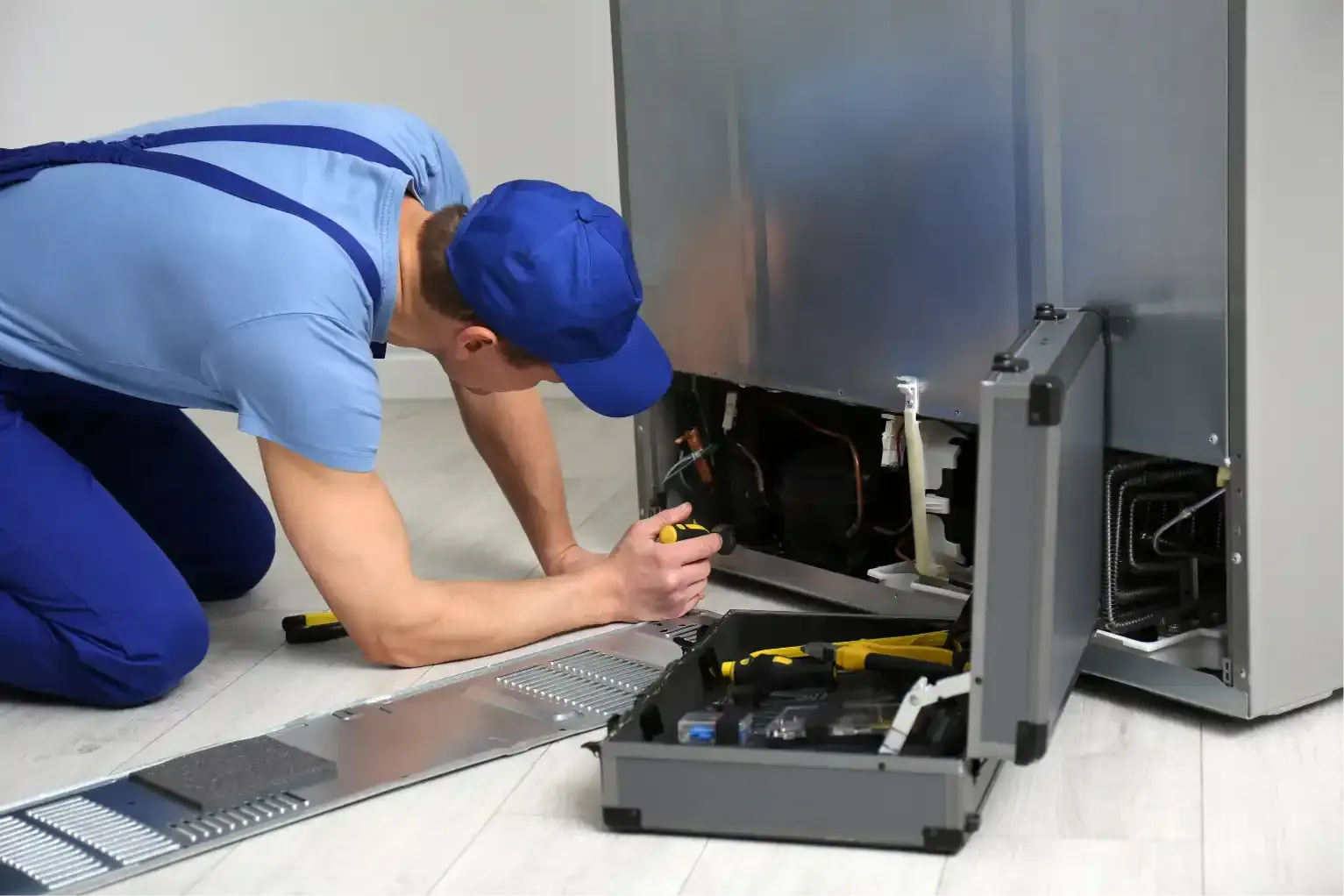 Hand tightening a pipe fitting under a sink with adjustable wrenches