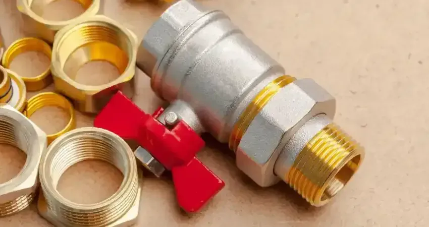 Hand tightening a pipe fitting under a sink with adjustable wrenches
