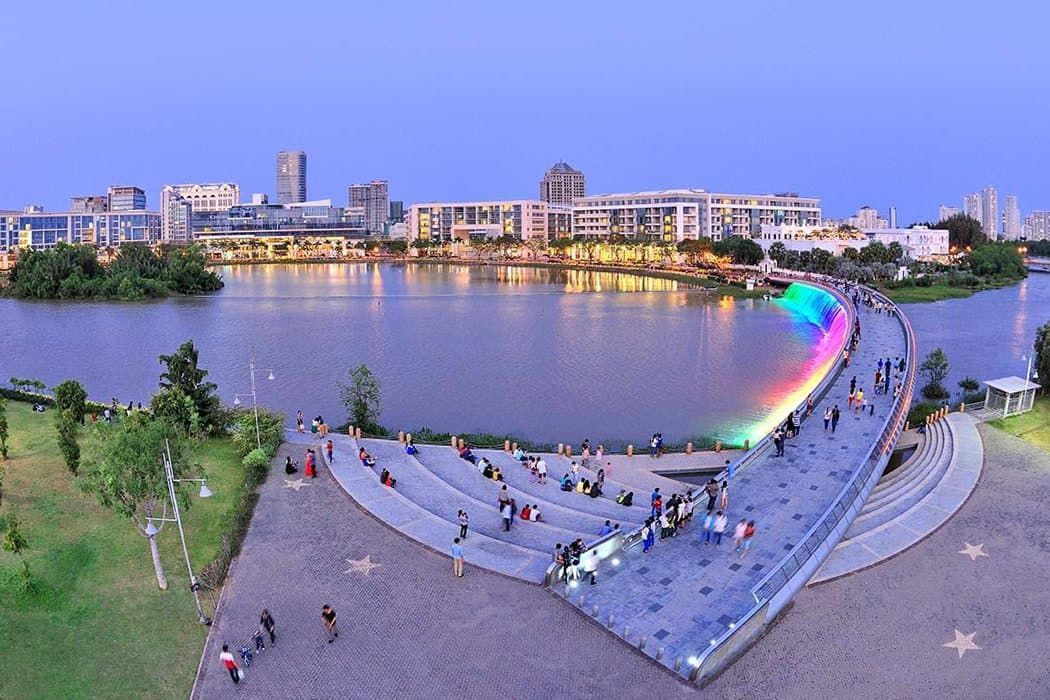 An aerial view of a lake with a rainbow in the middle of it.