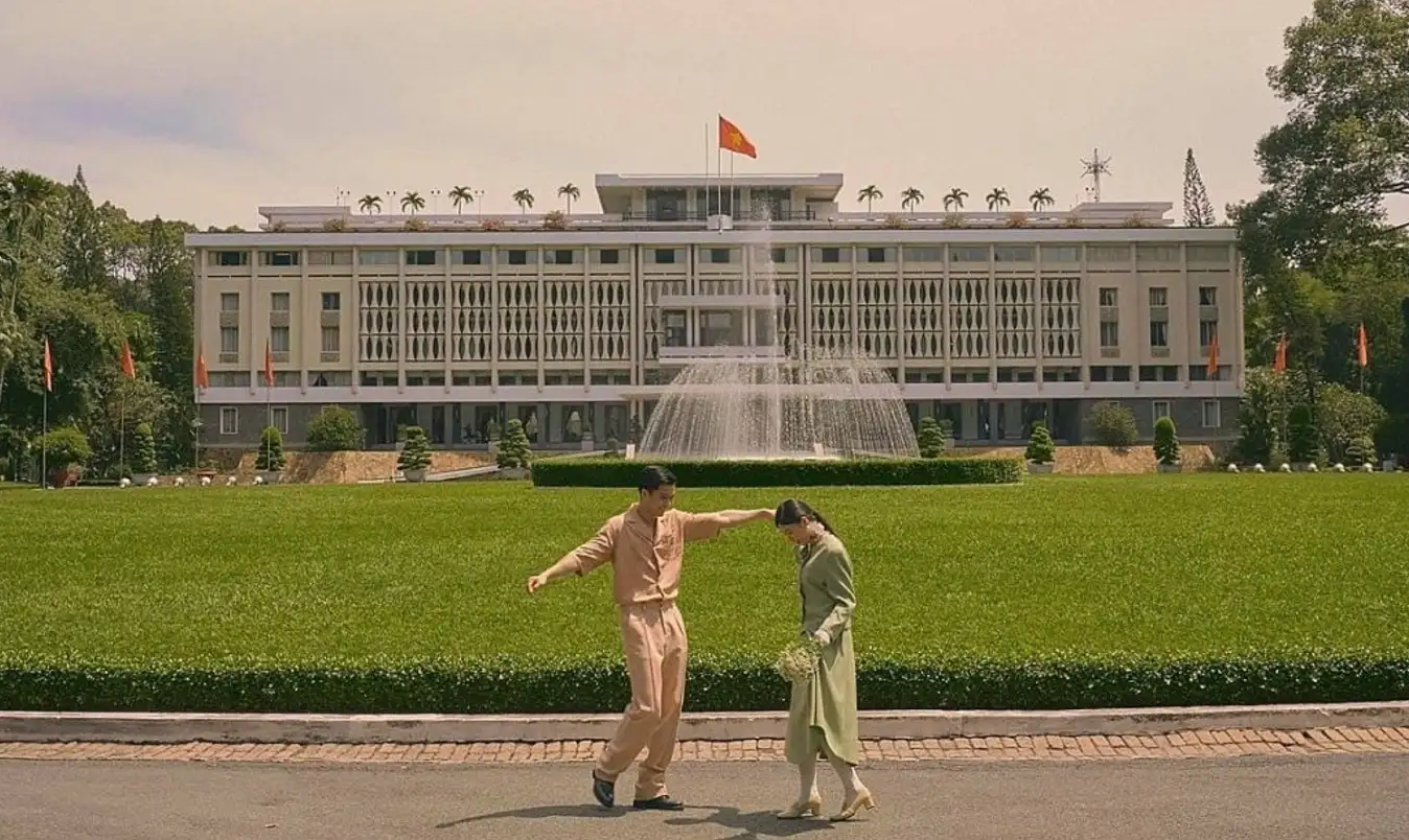 A man and a woman are dancing in front of a large building.