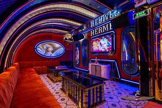 A karaoke room with a lot of furniture and a table.