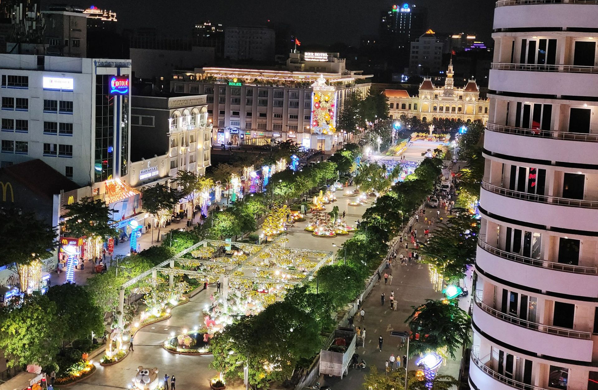 An aerial view of a city at night with lots of buildings and trees
