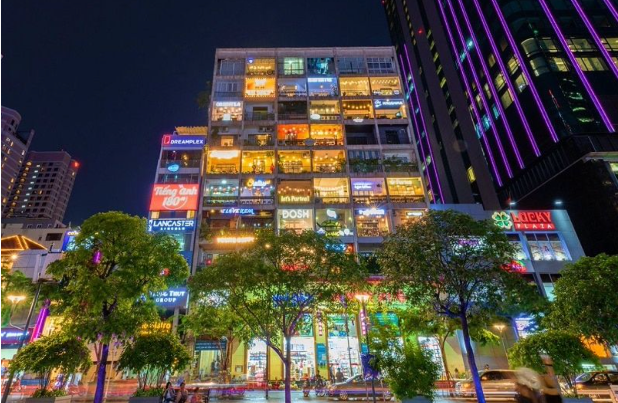 A large building with lots of windows is lit up at night.