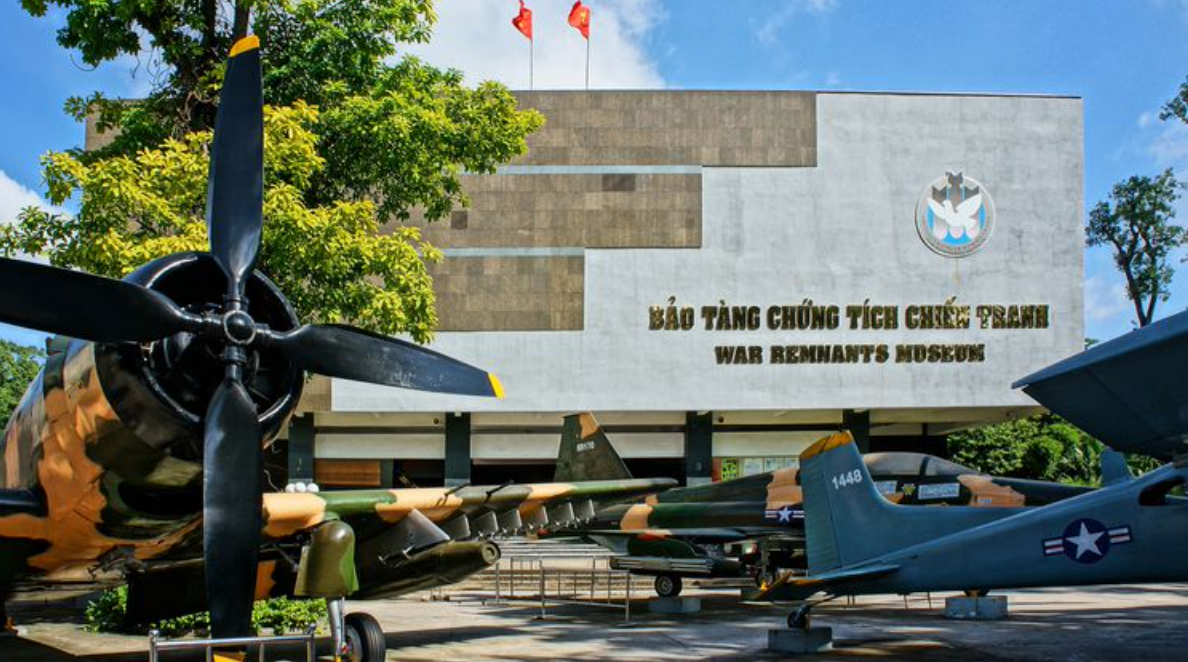 A group of military planes are parked in front of a building.