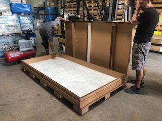 Large door assembly supported by a heavy-duty corrugated pallet featuring additional Ecodek blocks and an open bottom deck.