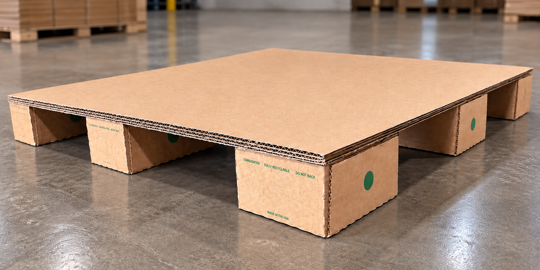 Corrugated cardboard shipping pallet no bottom deck resting on a warehouse floor.