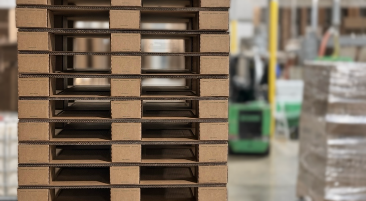 Corrugated cardboard shipping pallet resting on a warehouse floor.