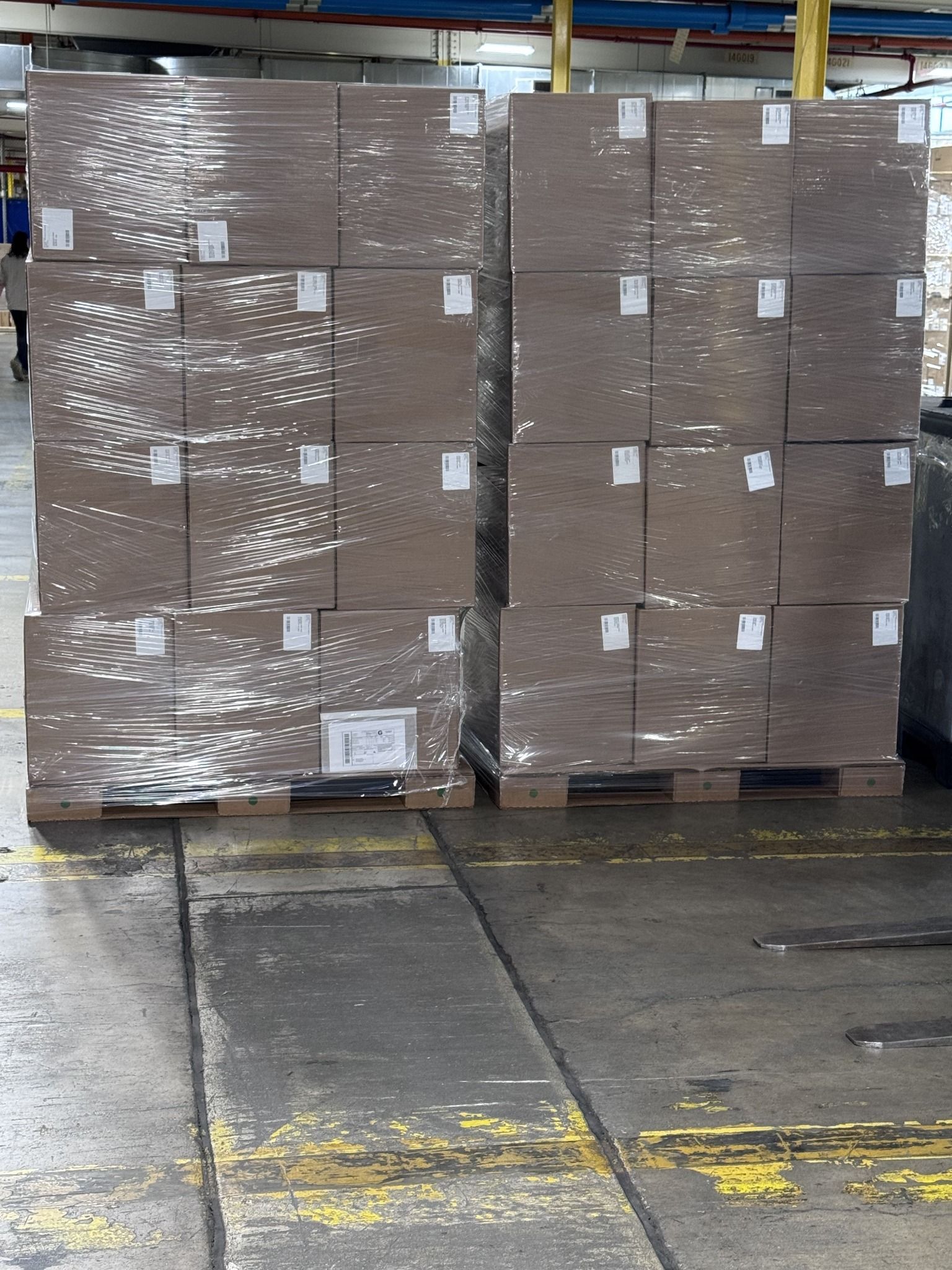 Two large stretch-wrapped loads of shipping cartons supported by Ecodek corrugated pallets, prepared for distribution.