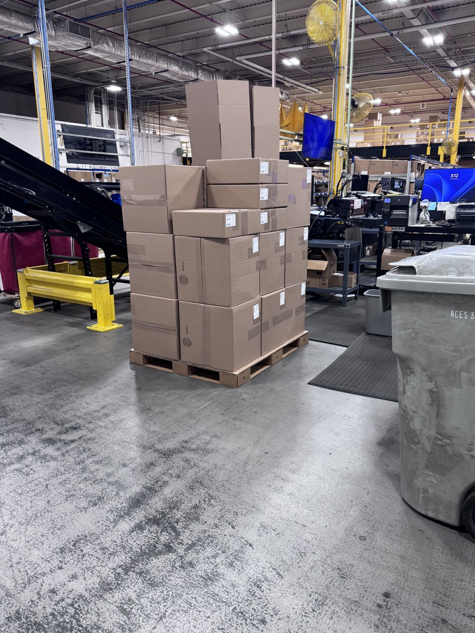 Mixed-size shipping cartons stacked on a corrugated pallet in a warehouse packaging operation.
