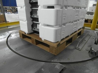 Large component secured in white foam packaging on a corrugated pallet with tall support blocks and a reinforced top deck.
