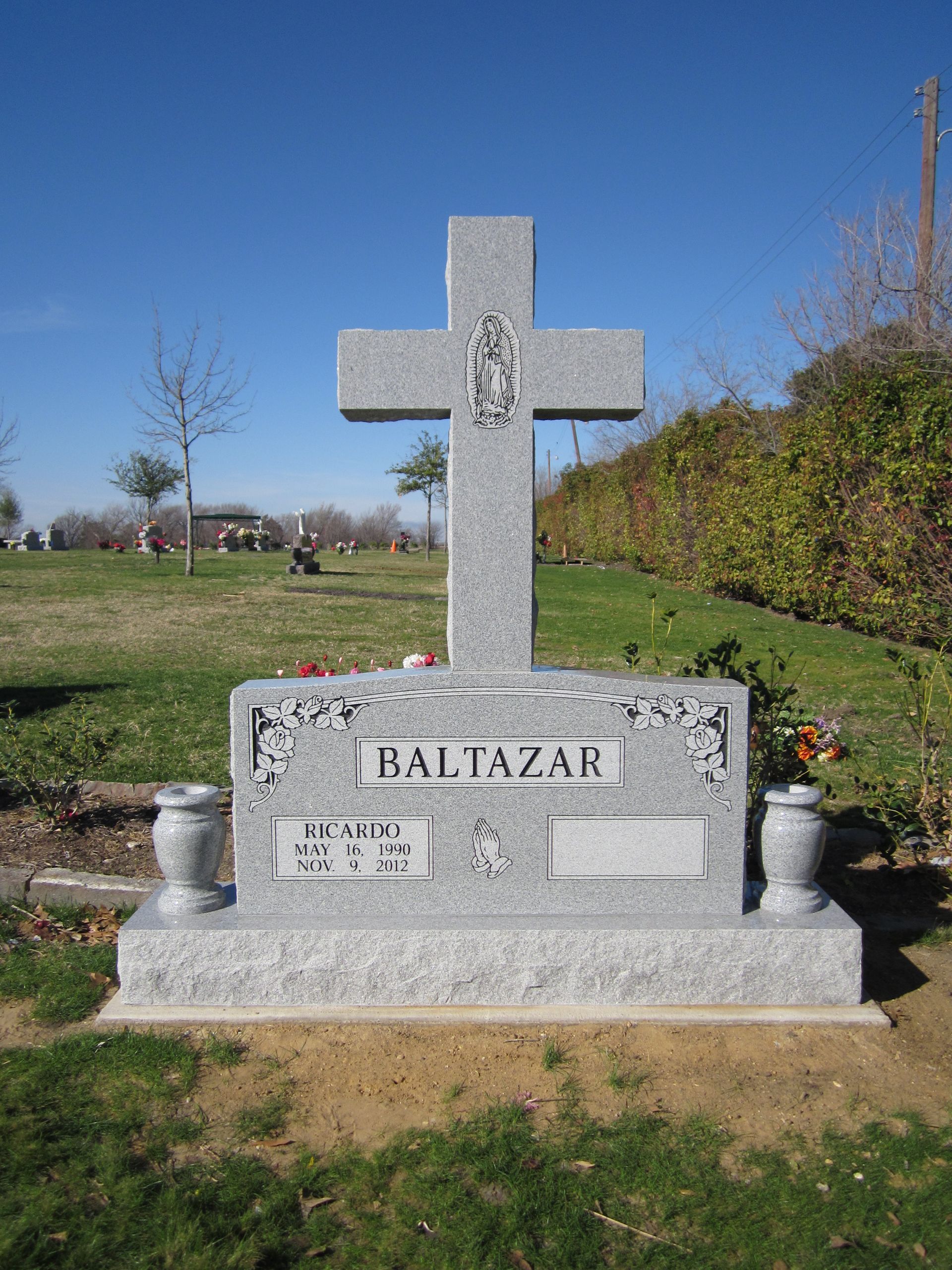 Gray granite cross-shaped headstone with 