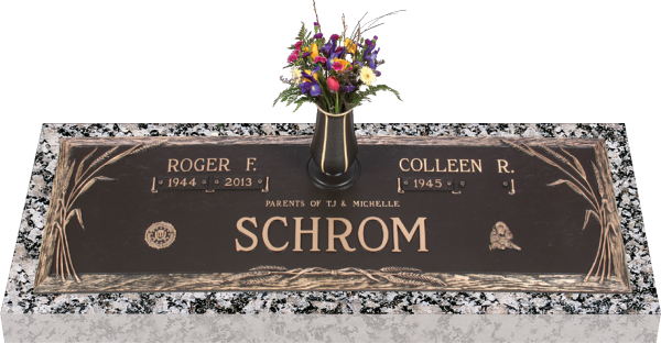 Bronze cemetery headstone with a flower vase. Names Roger F. and Colleen R. on it.
