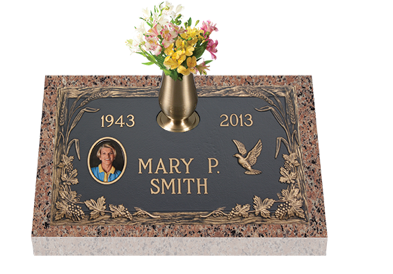 Headstone with vase of flowers; includes woman's photo, birth/death years, name, and dove symbol.